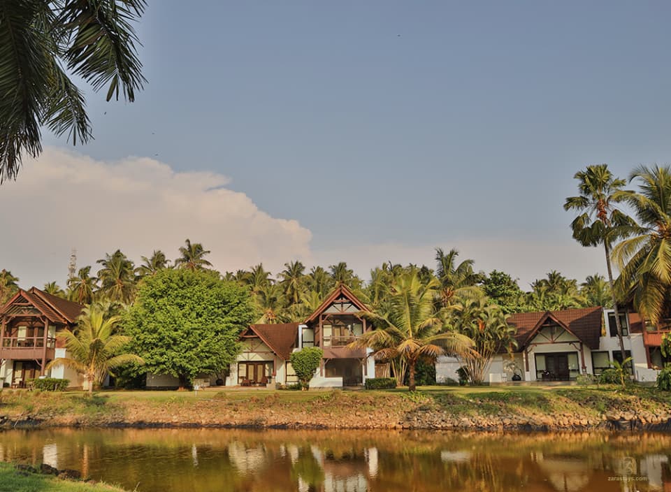 Palm-lined waterside grounds at The LaLiT Bekal