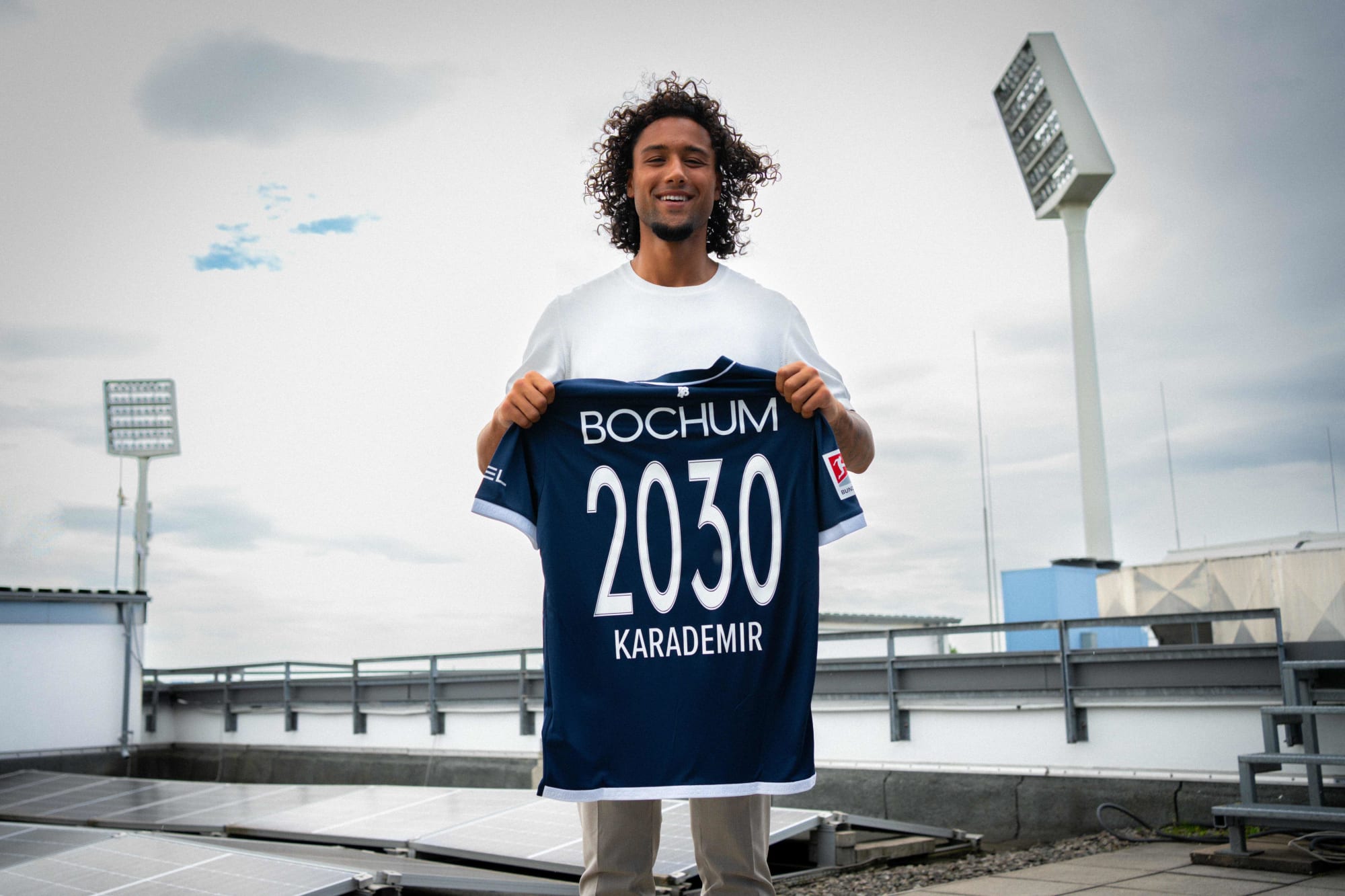 Yigit Karademir ist neu beim VfL Bochum 1848 und hält sein Trikot mit der Zahl 2030 hoch.