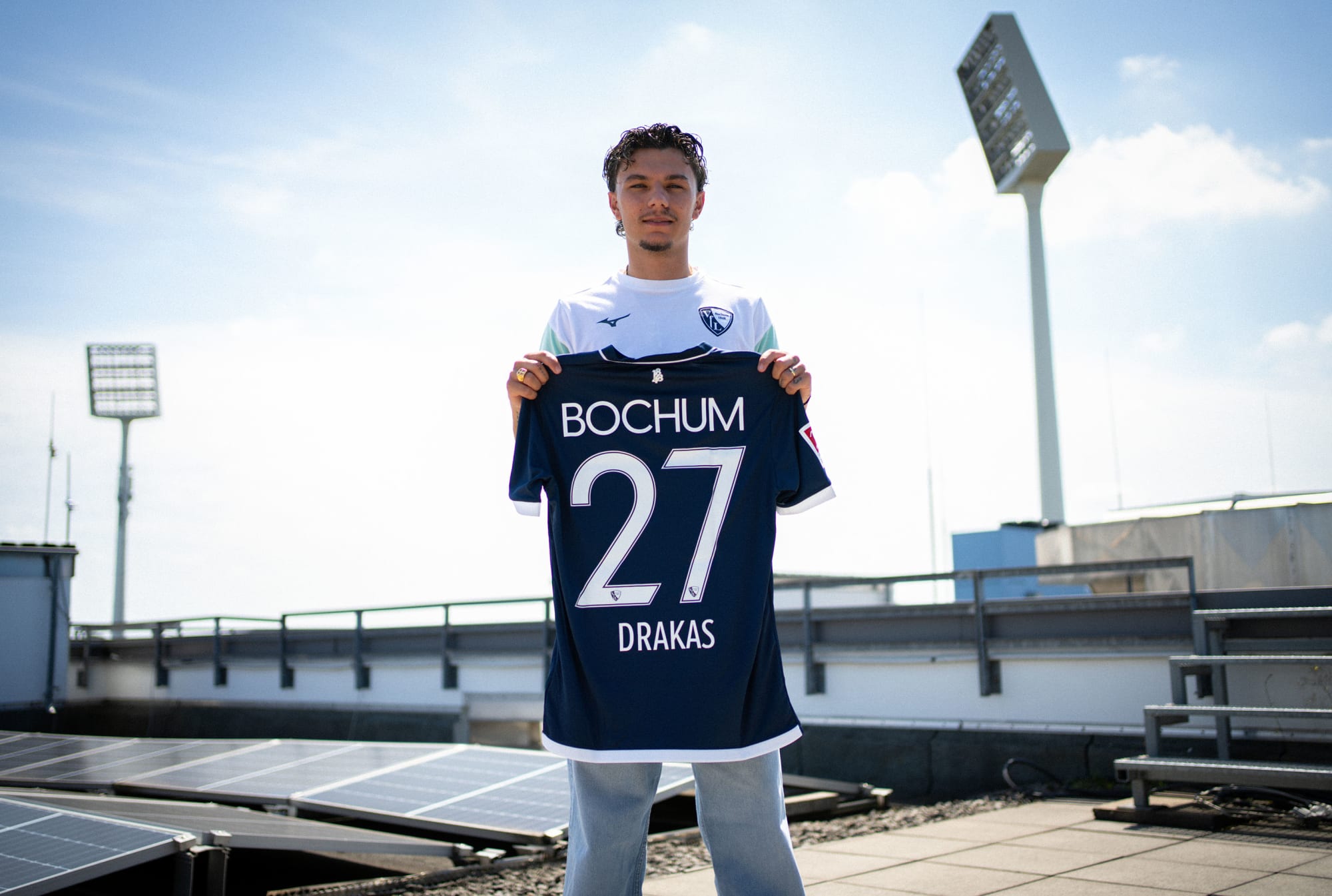 VfL-Neuzugang Babis Drakas hält das Trikot mit der Nummer 27.