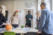 Groepje leerkrachten staand bij een tafel in overleg