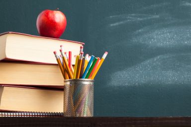 schoolbord met stapel boeken en appel