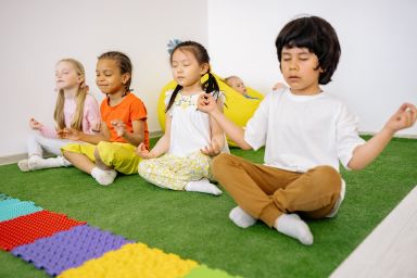 4 kinderen in kleermakerszit en in meditatie