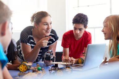 Jonge juf techniek met een groep van kinderen