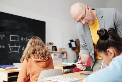man geeft les aan kinderen in de klas