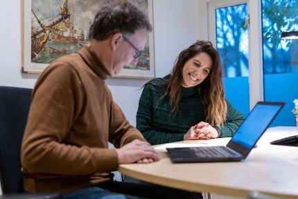 man en vrouw kijken samen naar laptop