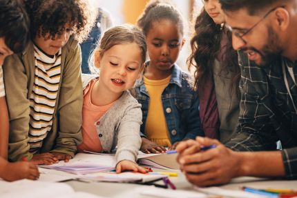 kinderen op de basisschool zijn met een docent aan het kleuren