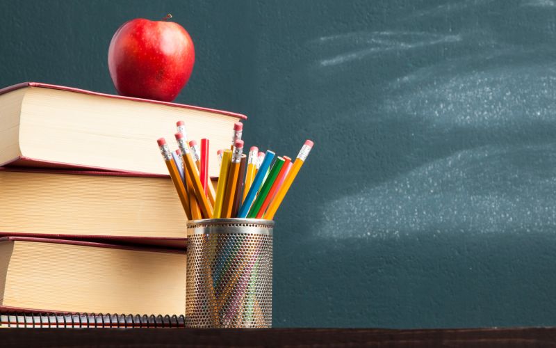 schoolbord met stapel boeken en appel