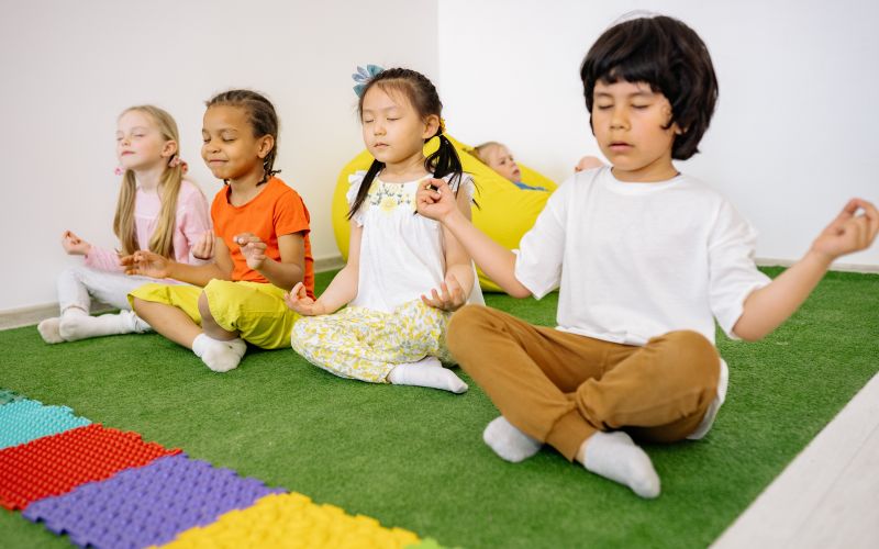 4 kinderen in kleermakerszit en in meditatie
