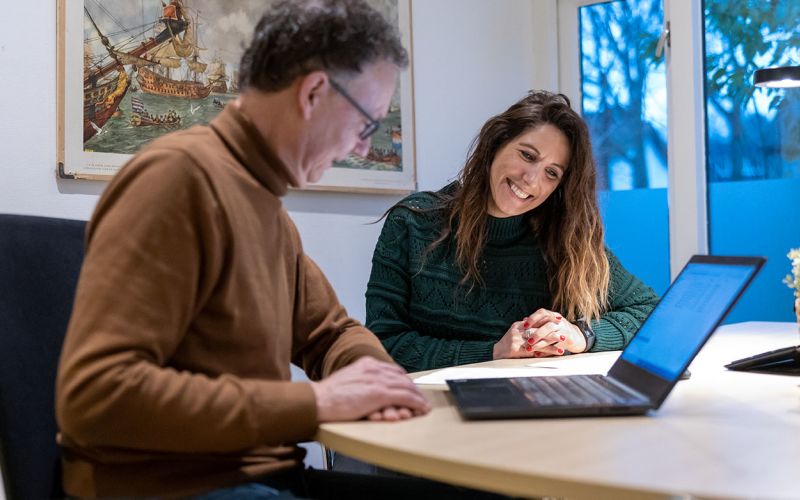 Man en vrouw kijken samen naar laptop