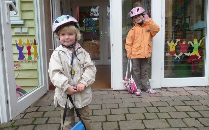 Kinderen met helm op schoolplein