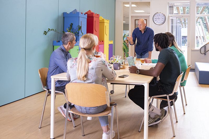 een tafel vol docenten die praten