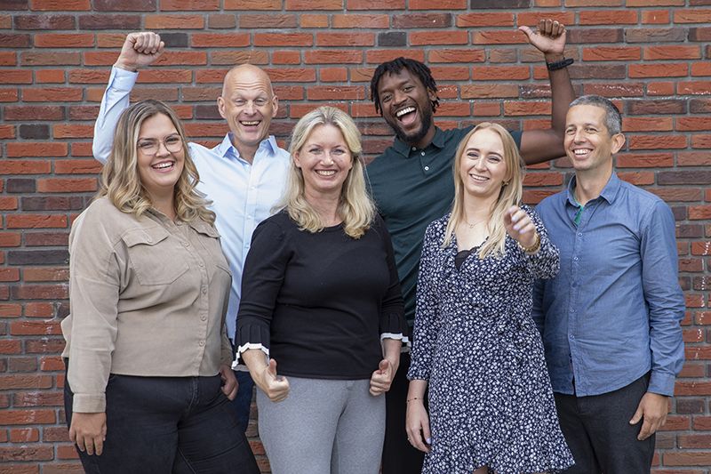 Team leerkrachten op schoolplein juichend 