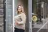 Portret van jonge leerkracht die in deuropening ingang school staat