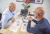 Schooldirecteur en VfPf adviseur in gesprek met rapport op tafel
