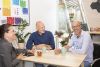 3 personen op foto, 2 mannen en 1 vrouw met kopjes koffie