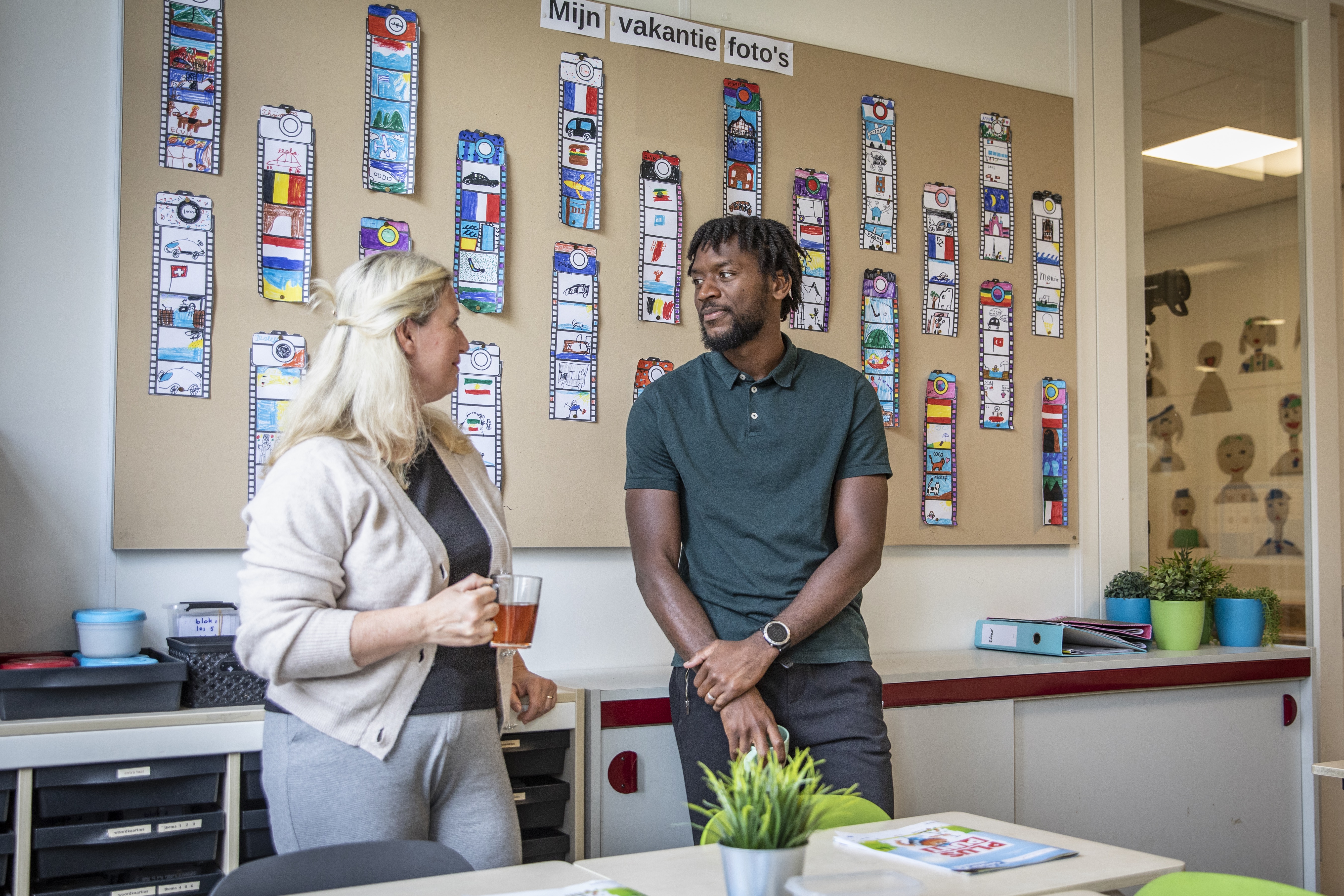 twee leerkrachten in een klaslokaal in gesprek met elkaar over ziekteverzuim
