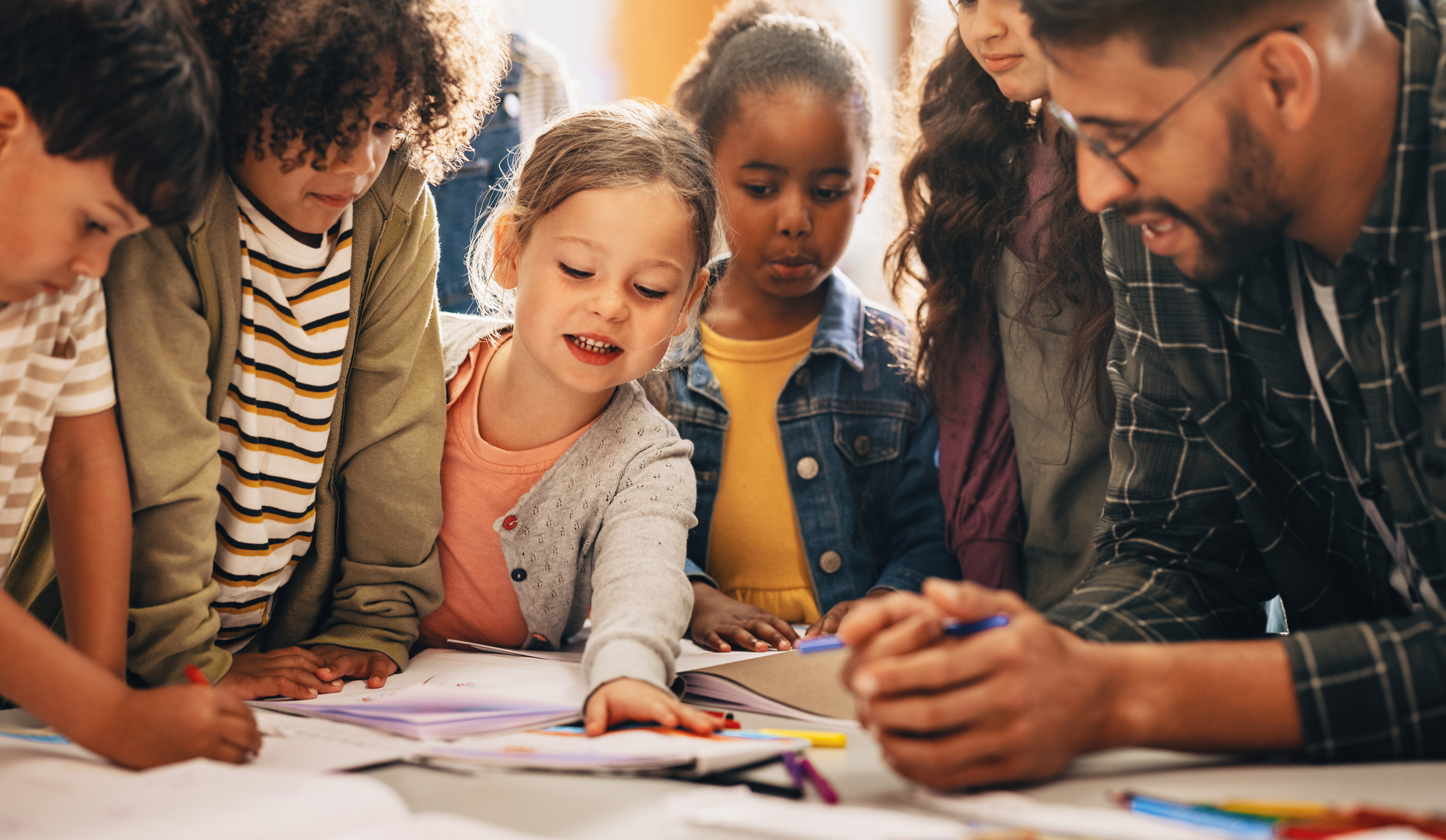 kinderen op de basisschool zijn met een docent aan het kleuren