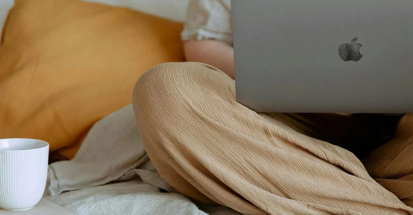 A creative workspace with a laptop, coffee and warm neutral textures