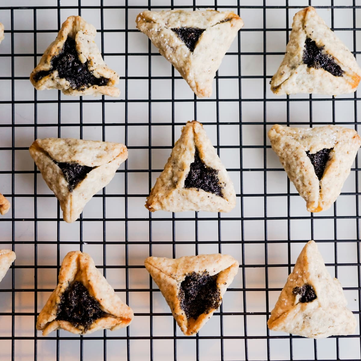 baked hamantaschen with poppy seed on a wire rack