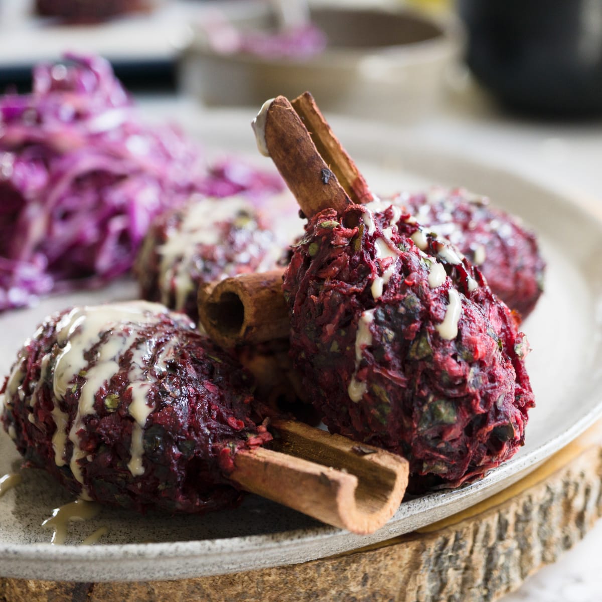 vegan beet kebab on cinnamon sticks with tahini and red cabbage salad