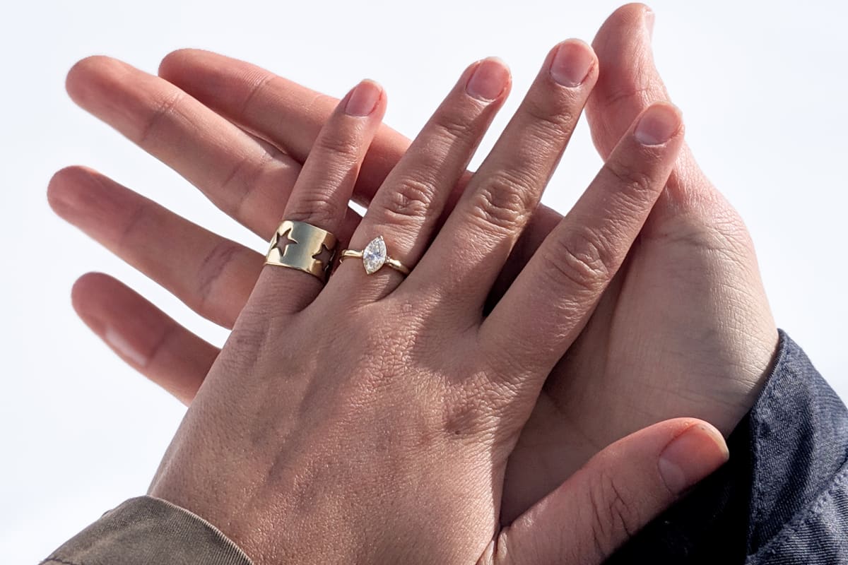 our hands together with the engagment ring