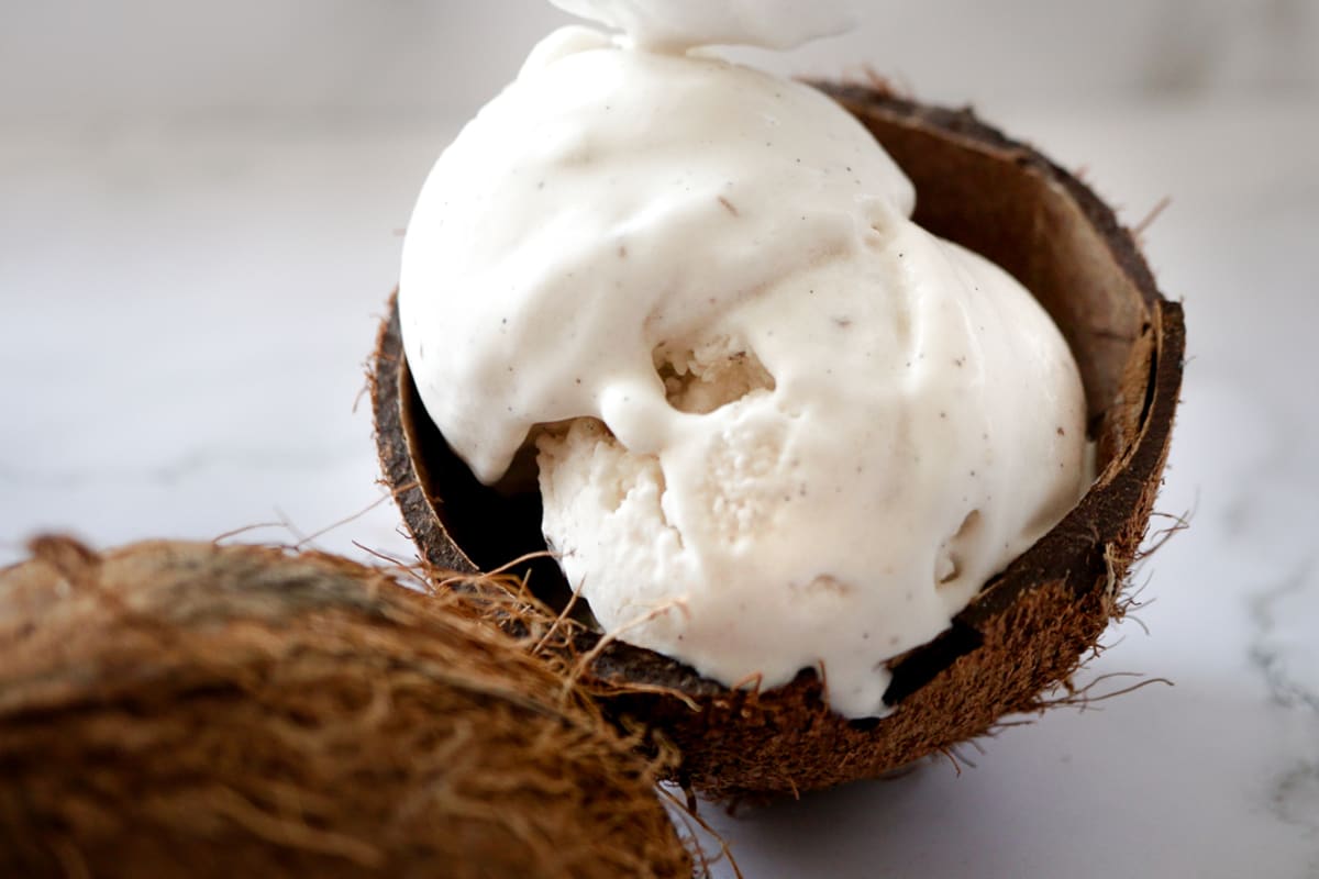 topping the coconut ice cream with a spoon of coconut whipped cream