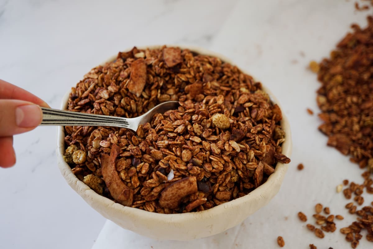 holding a spoon in a bowl of coco pops granola