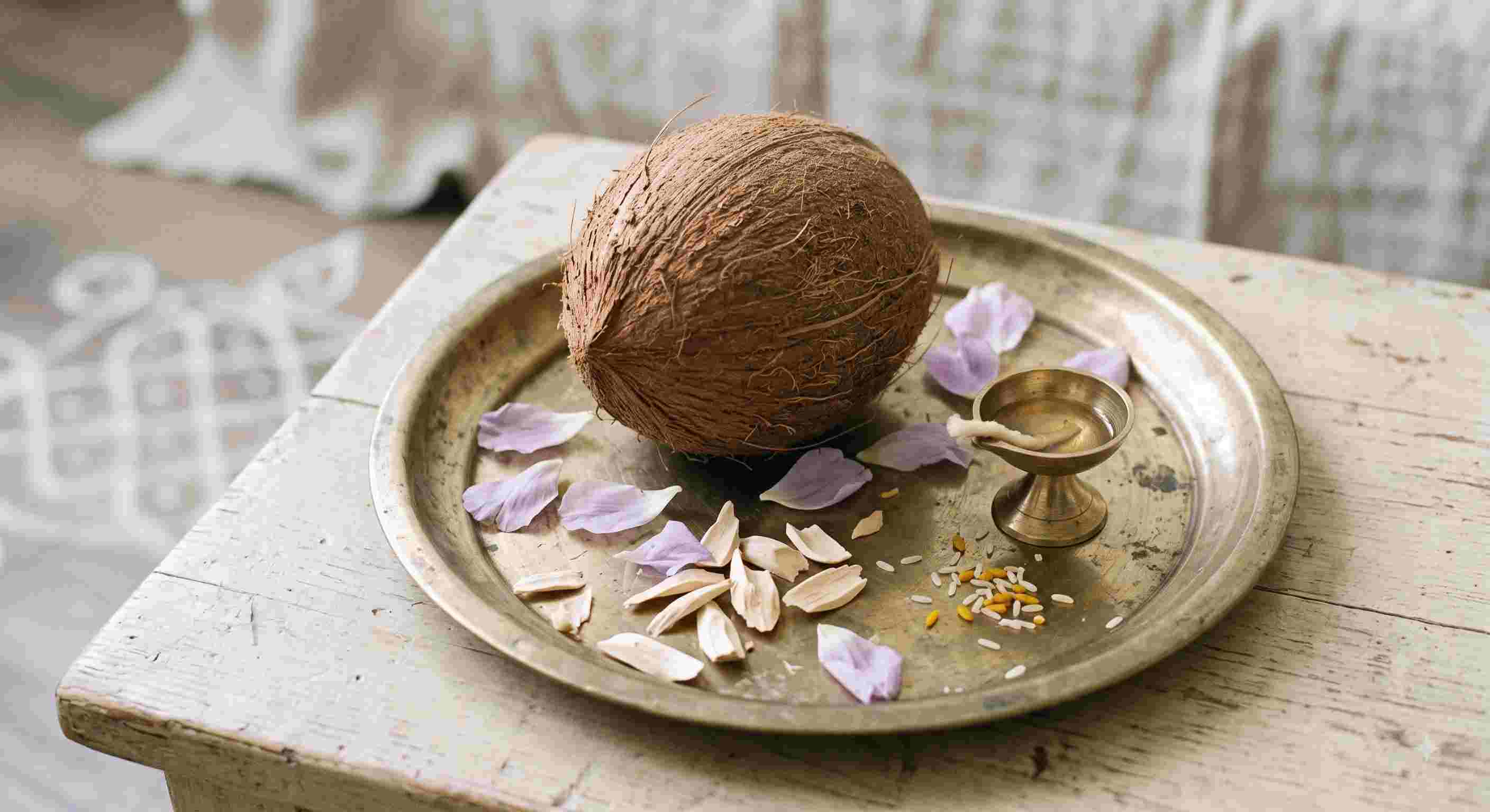 Man breaking a coconut during a traditional Hindu ritual while offering prayers