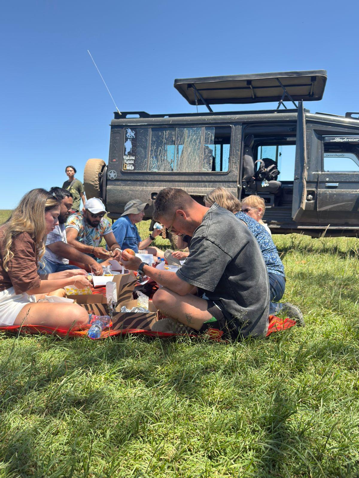 Open safari vehicle with guests viewing elephants on the savanna