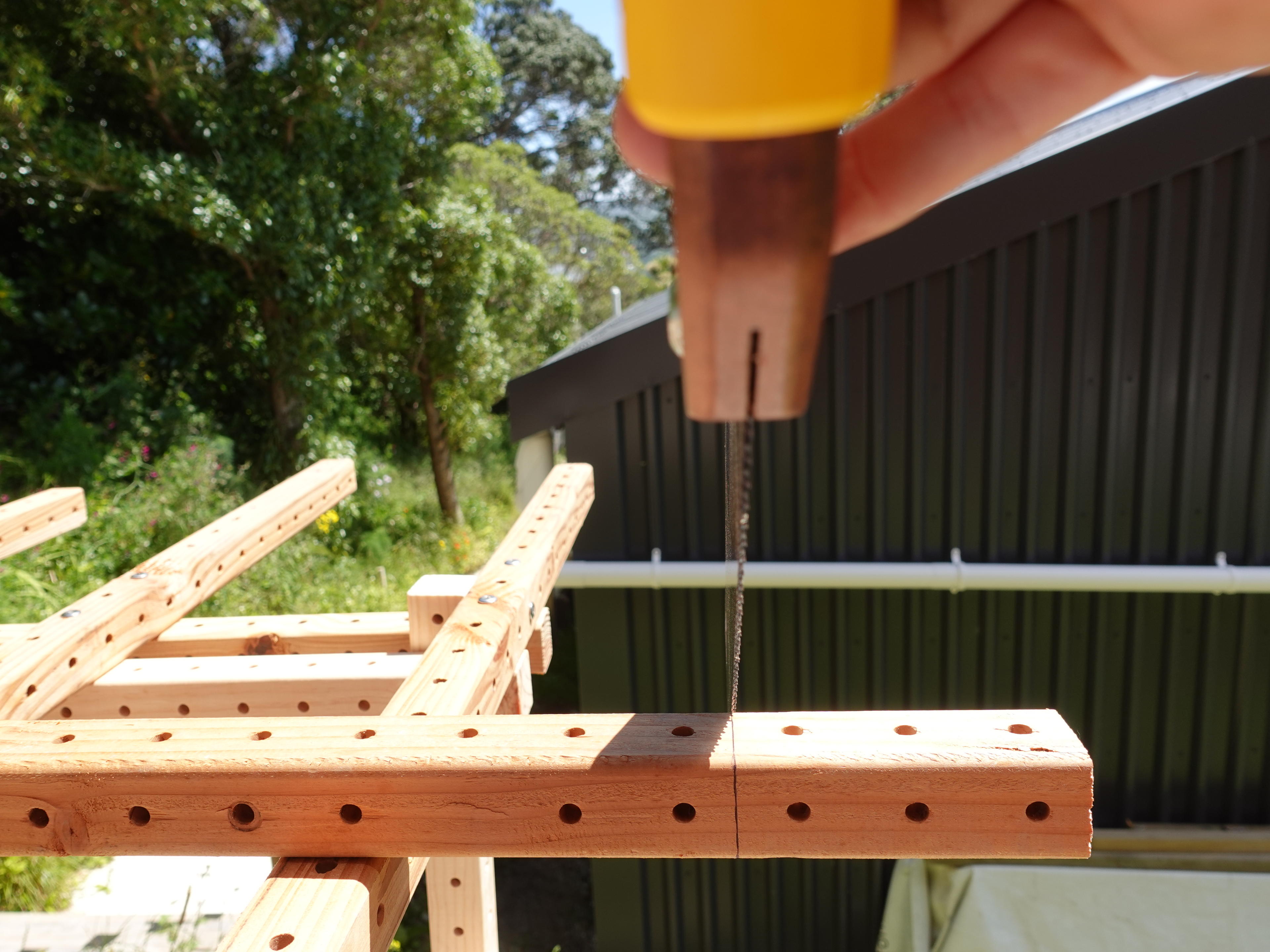 Saw blade straight on as it’s cutting through a beam making a visible kerf.