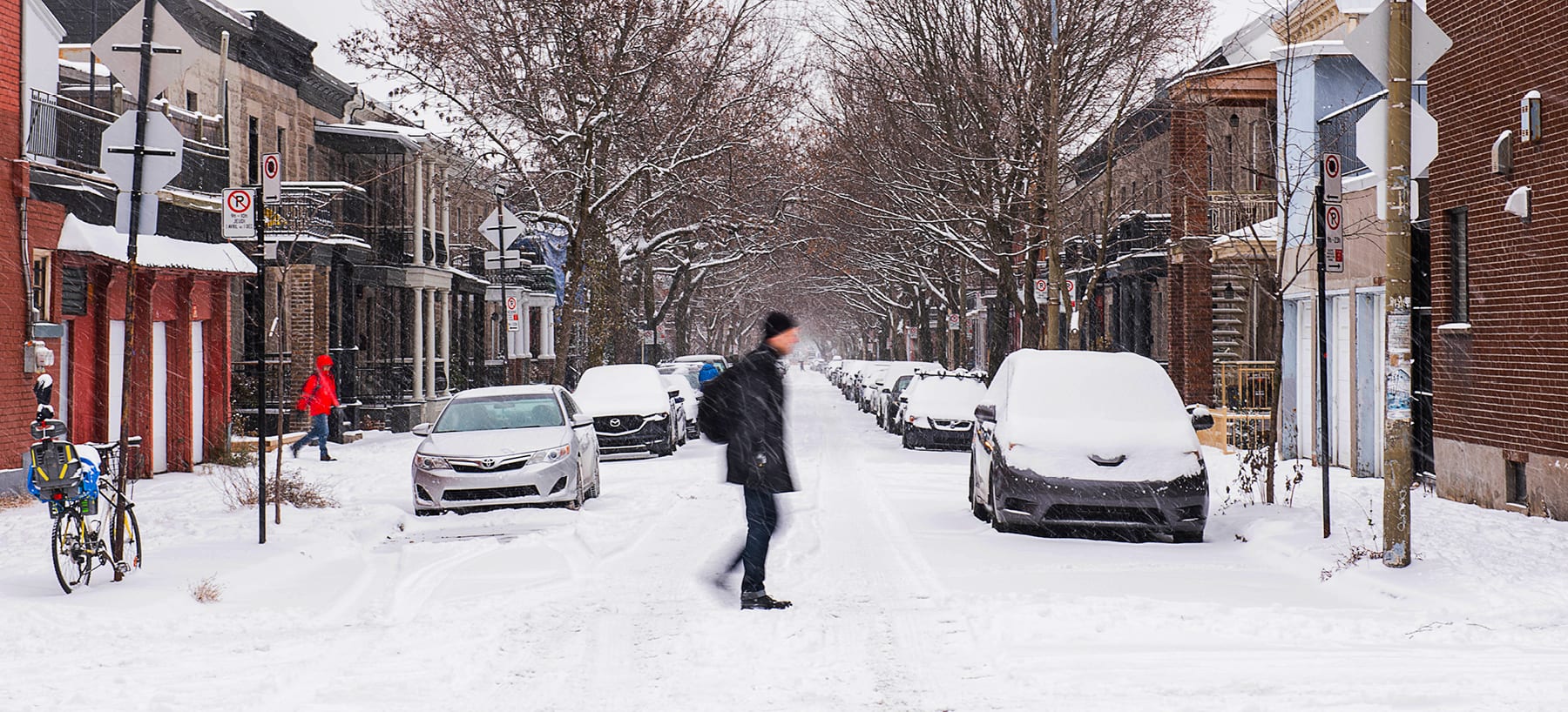 Piéton traversant une rue enneigée
