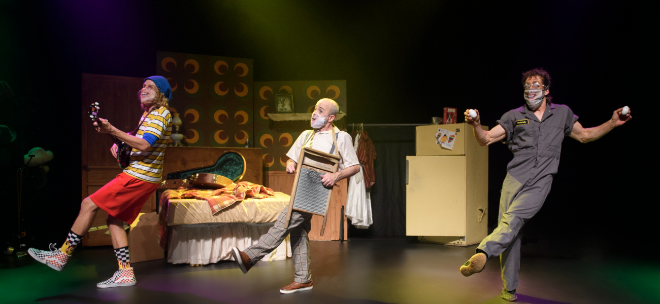 Trois personnages clownesques dansent en jouant de la musique.