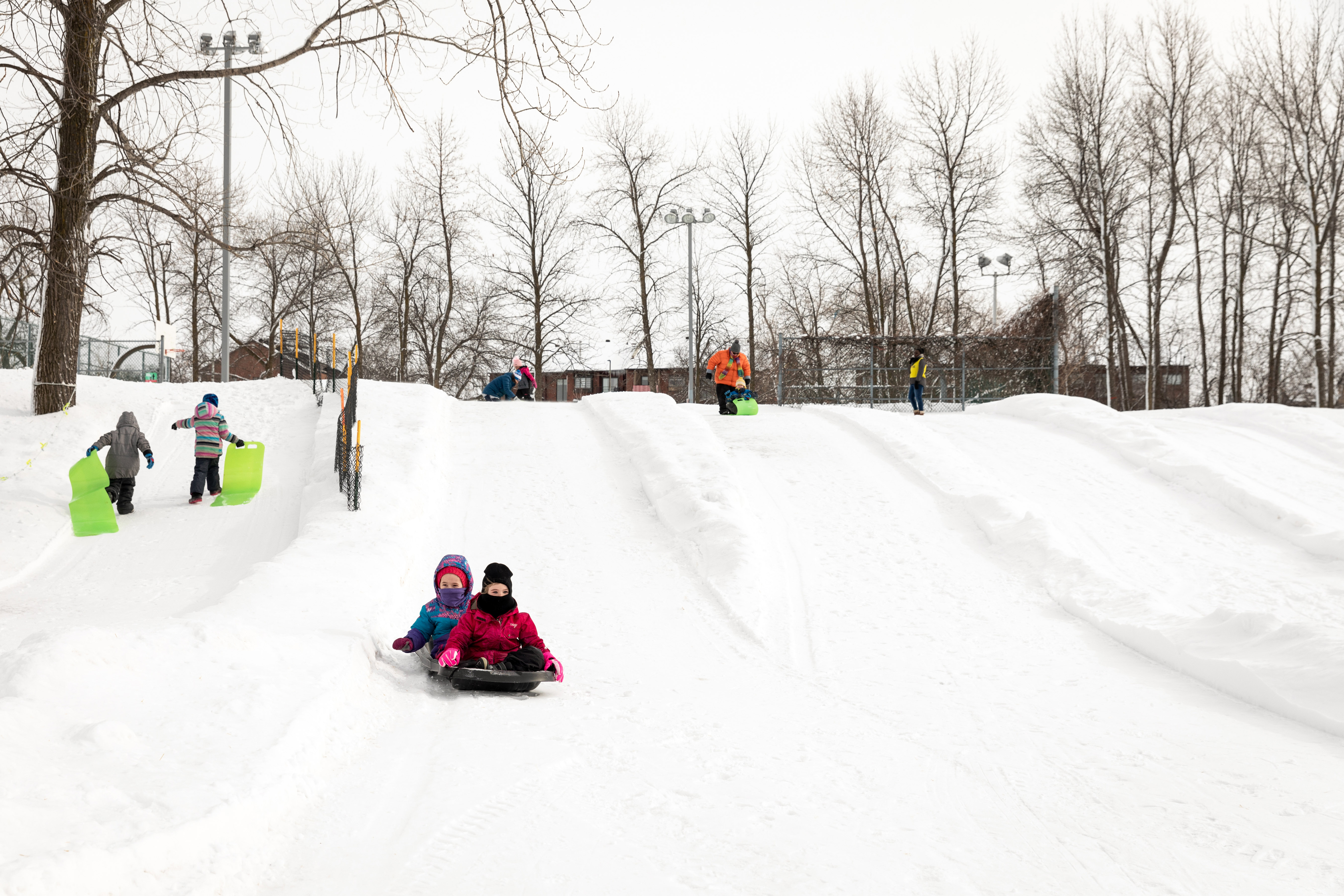 Enfants qui glissent sur une butte de neige.