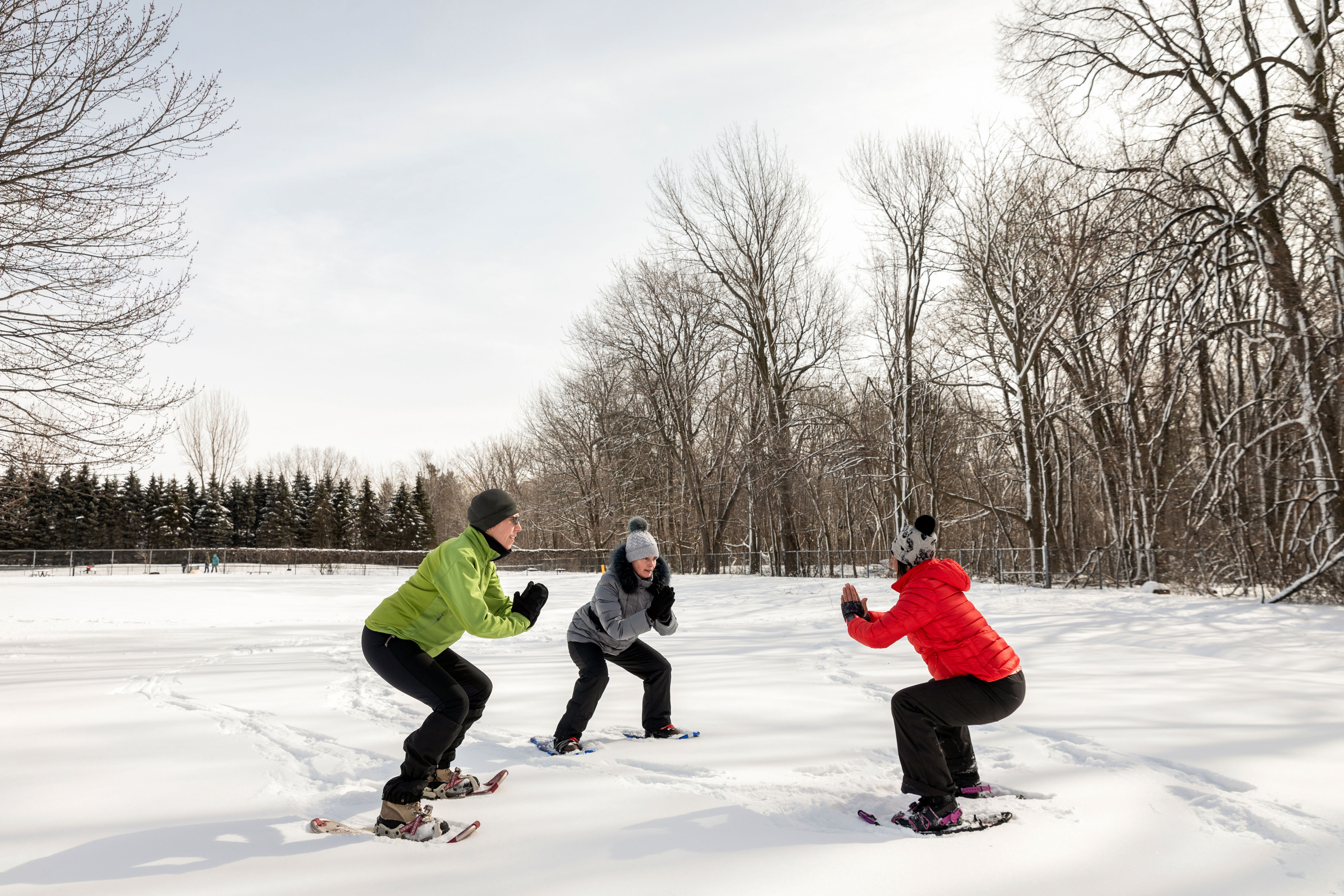 Trois personnes font du cardio-raquette dans la neige.