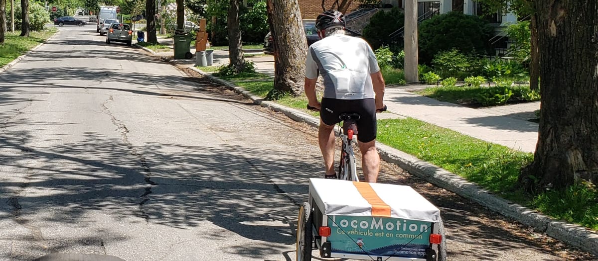 Personne qui se déplace avec un vélo à remorque