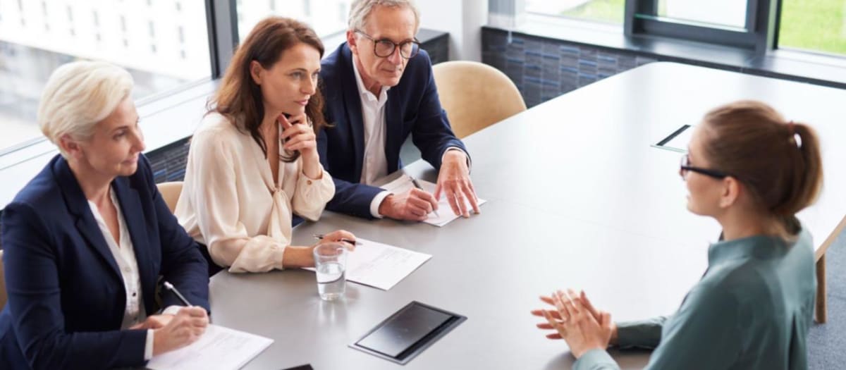 Trois recruteurs face à une candidate durant une entrevue