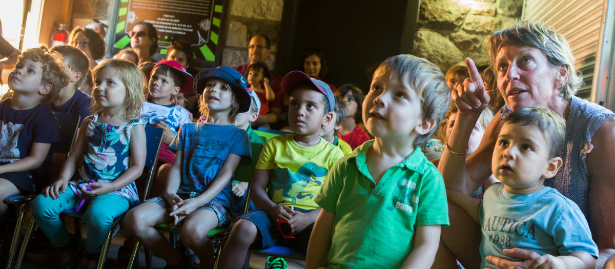 Des enfants assis par terre assistent à une activité
