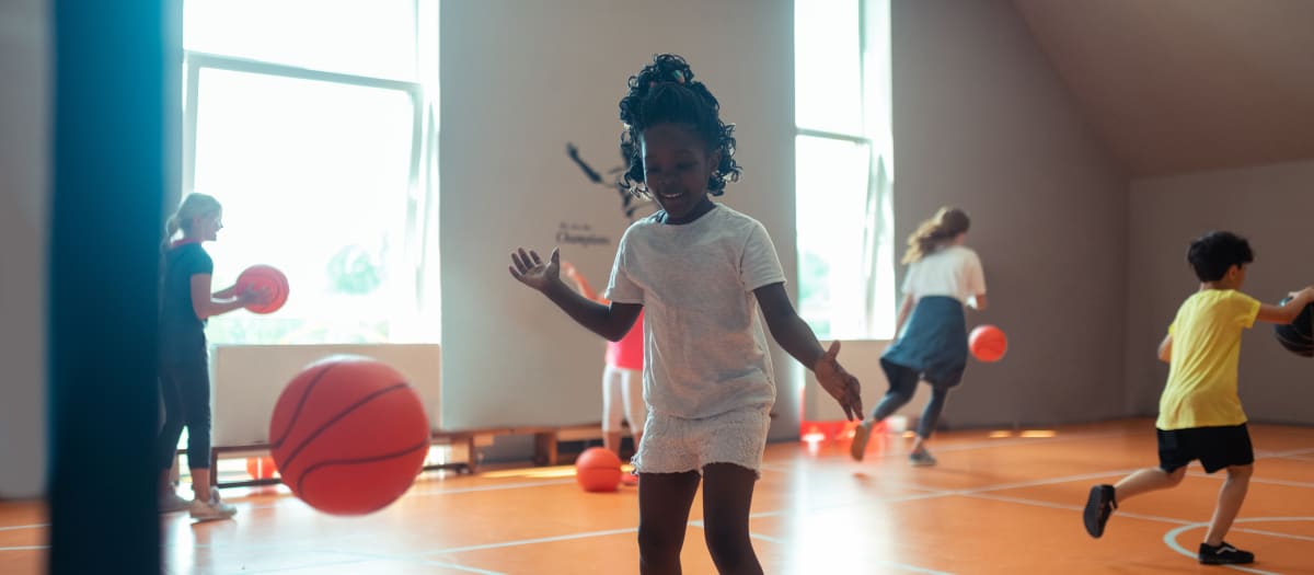 Enfants jouant au ballon dans un gymnase