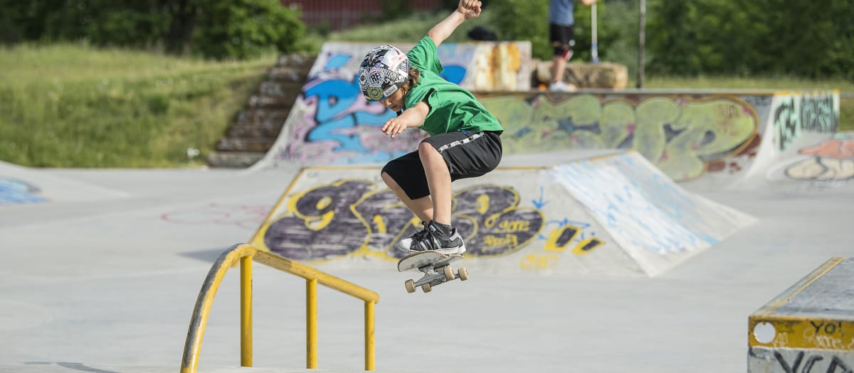 Un jeune garçon s'exerce à la planche à roulettes dans un skatepark
