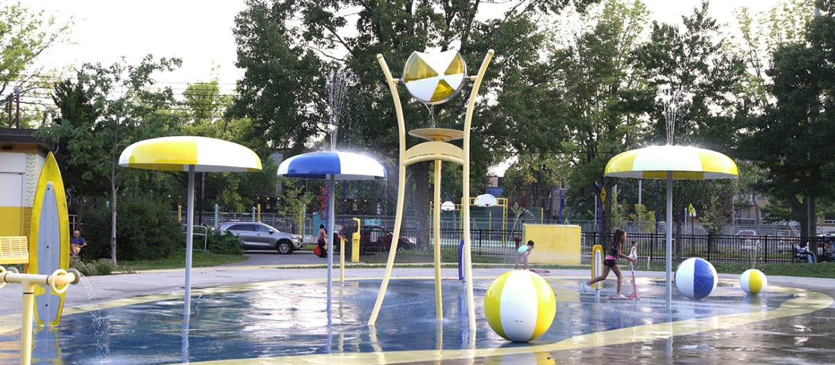 Un enfant en train de jouer dans les jeux d'eau du parc Gary Longhi.