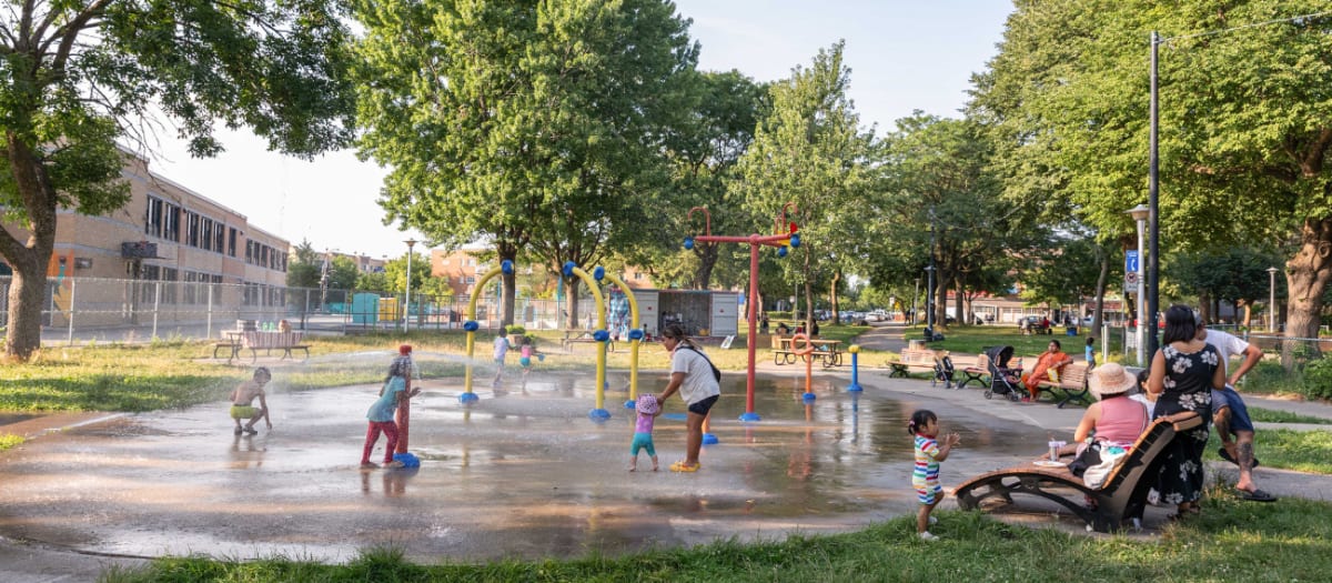 Famille s'amusant dans les jeux d'eau du parc