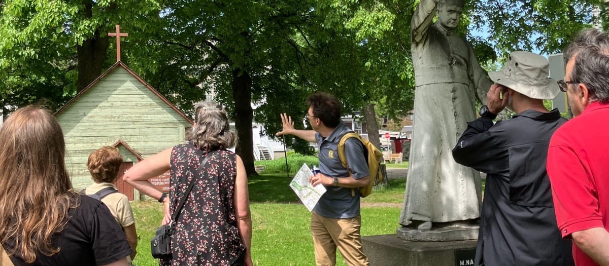 Un guide donne des explications sur un bâtiment à un petit groupe.