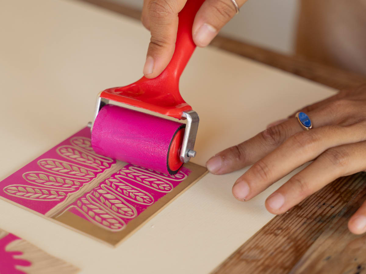 rouleau d'encrage rose sur une matrice à motif végétal