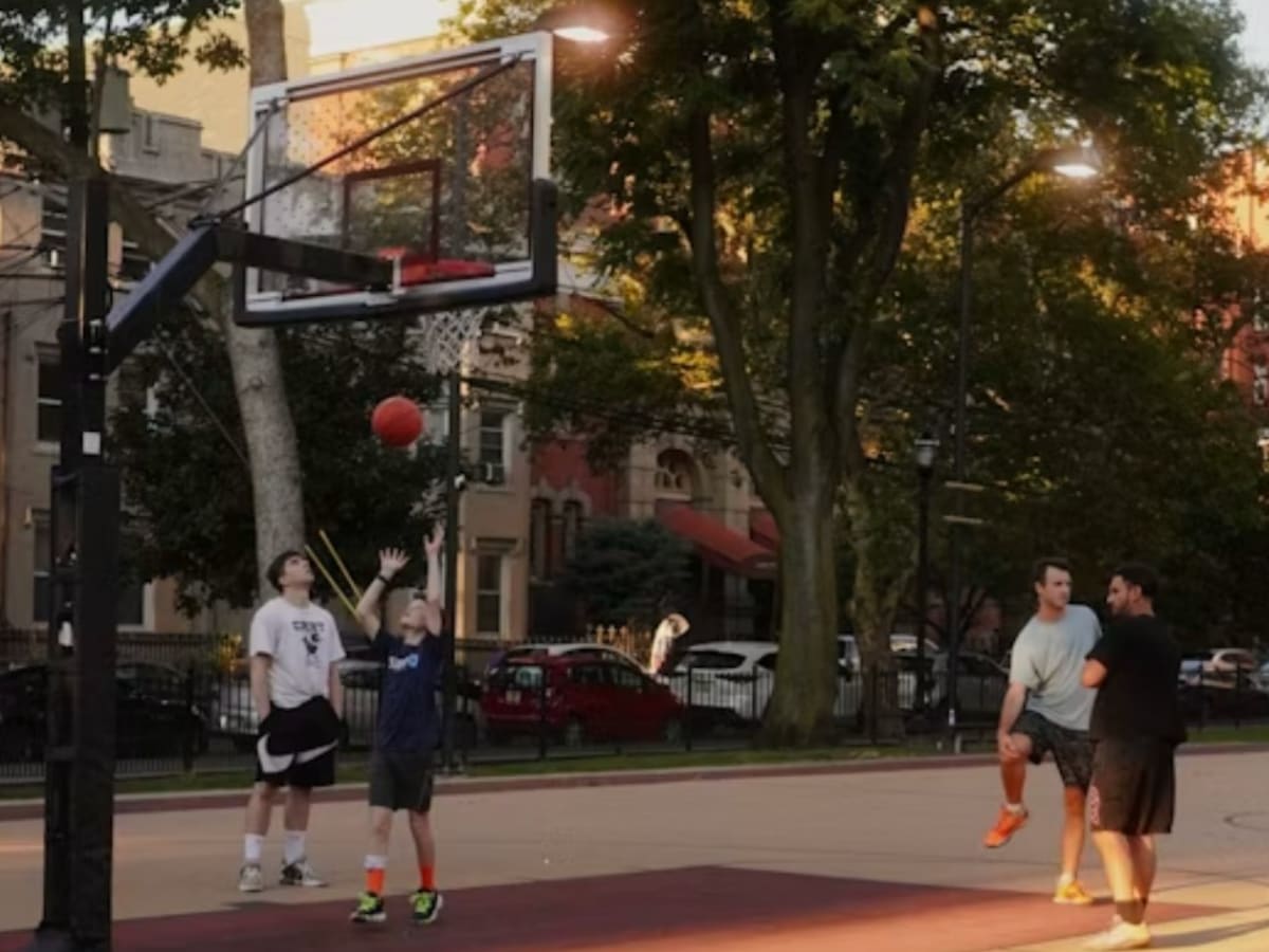 Des jeunes s'amusent sur un terain de basketball. - Group of young people are having fun on a basketball court.
