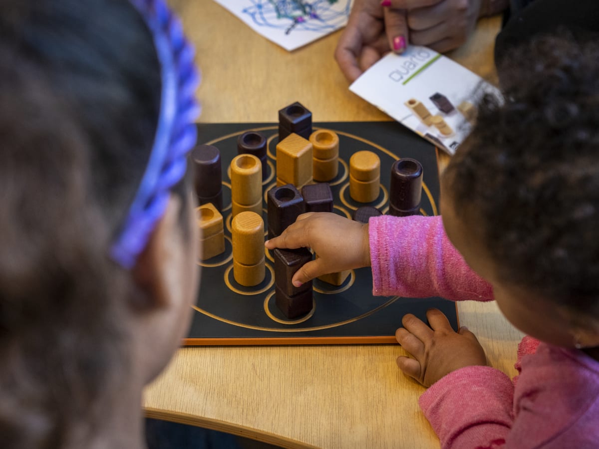 Deux filles jouant à un jeu de société à la bibliothèque Frontenac.