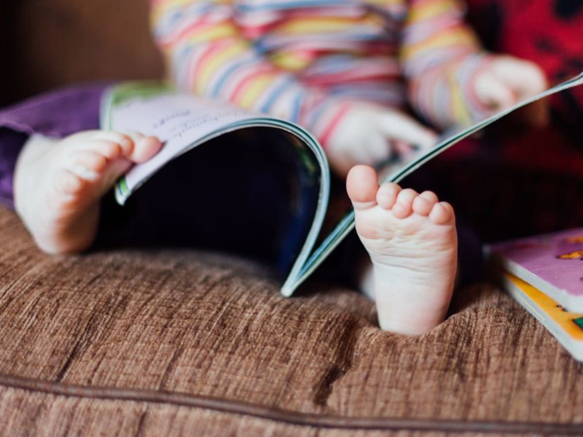 Un enfant en bas âge lit un livre.