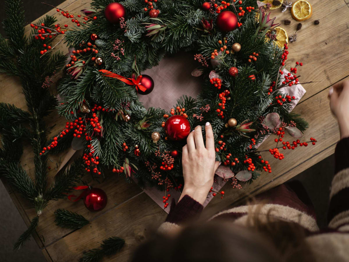 Une personne fabrique une couronne de Noël