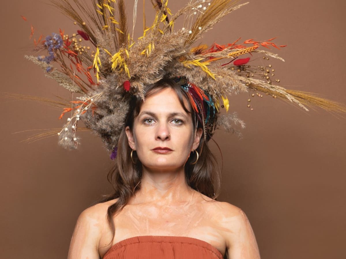 Photo de Juulie Rousseau avec une couronne faite de végétaux et de plumes