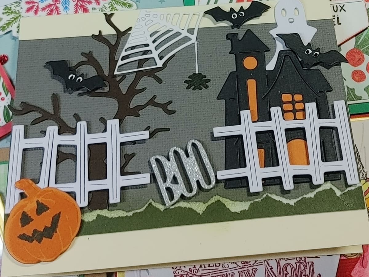 Photo d'une carte fait avec du collimage avec des motifs d'Halloween comme des citrouilles et une maison hantée