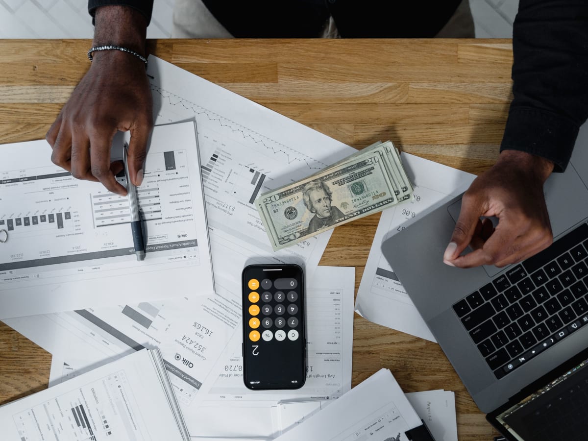 Une table remplis de papier et une calculatrice dessus